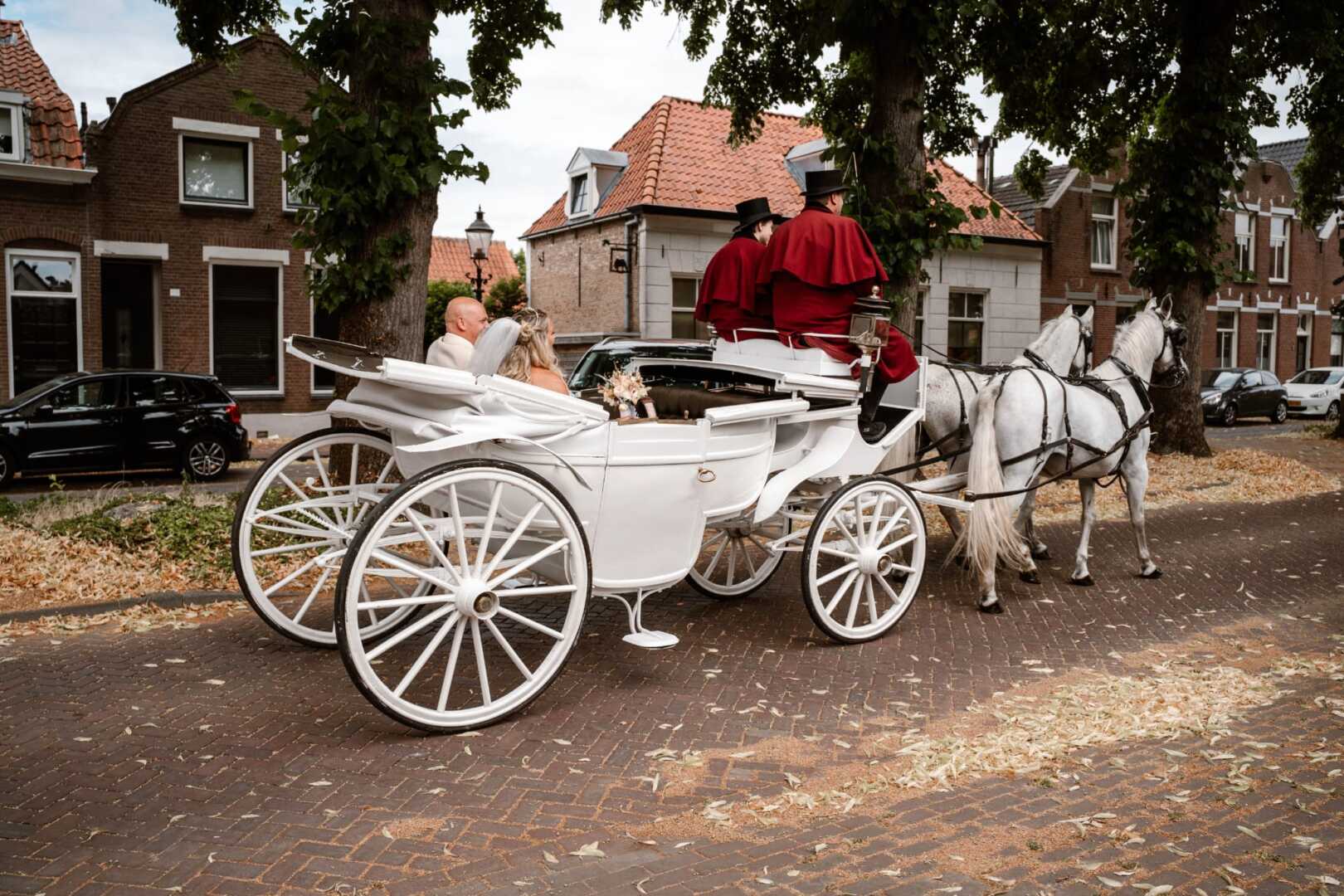 Witte glas landauer met span Schimmels tijdens een trouwerij in Geertruidenberg
