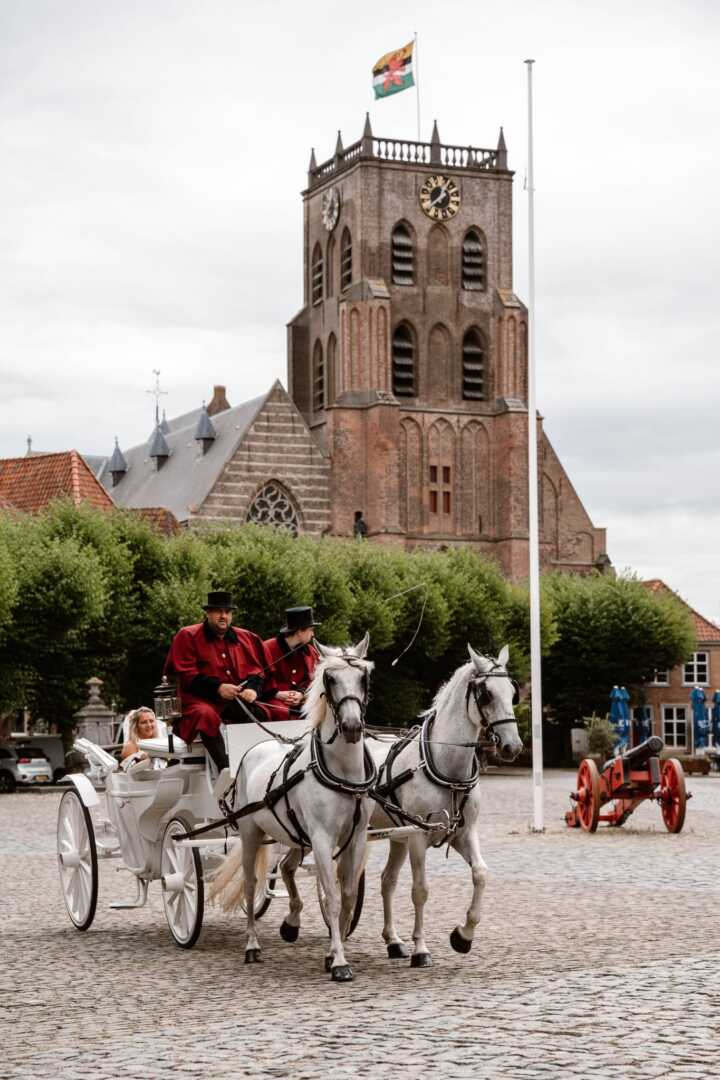 Witte glas landauer met span Schimmels tijdens een trouwerij in Geertruidenberg